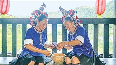     程陽(yáng)橋上，侗族婦女在展示制作侗族刺繡產(chǎn)品。繡品圖案精美、色彩艷麗，成為當(dāng)?shù)靥厣a(chǎn)業(yè)。